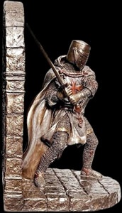 Nærbillede af bronzefigur forestillende middelalderlig tempelridder i detaljeret ringbrynje og rødt kors, fungerende som bogstøtte.